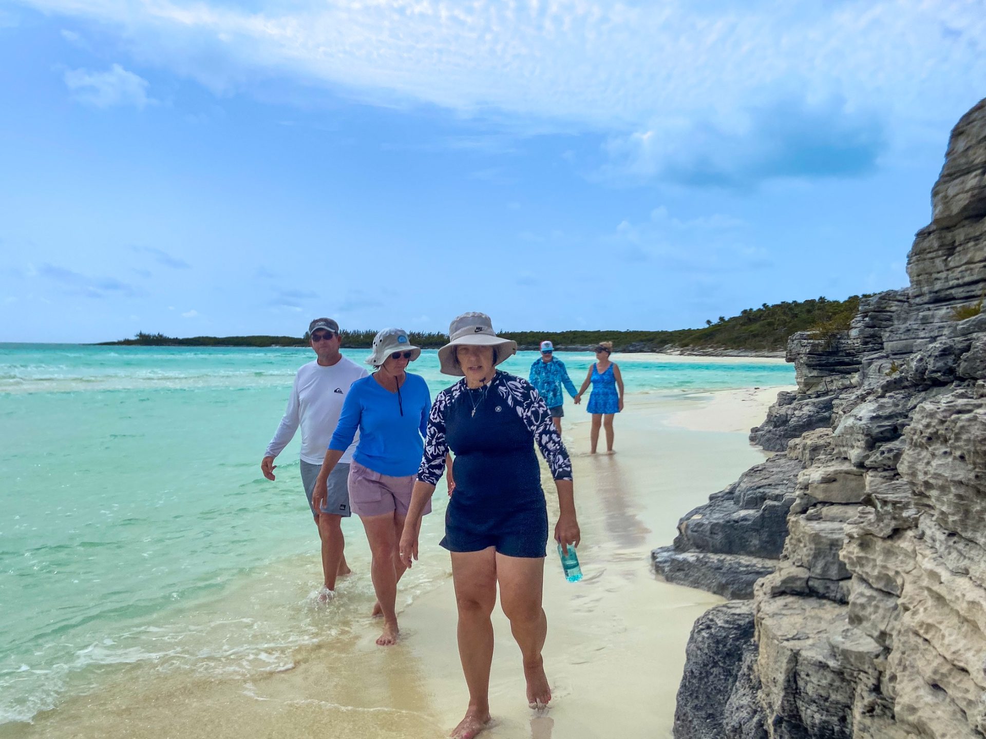 Guests walking a deserted Bahamian beach